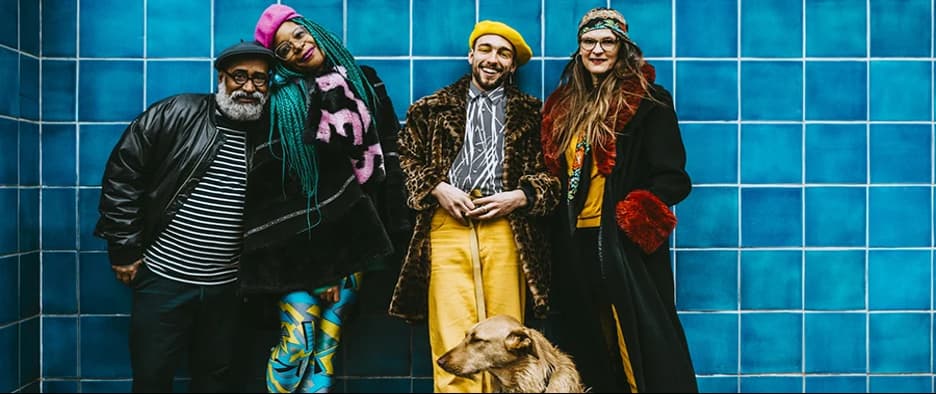 A group of people standing in front of a blue tile wall