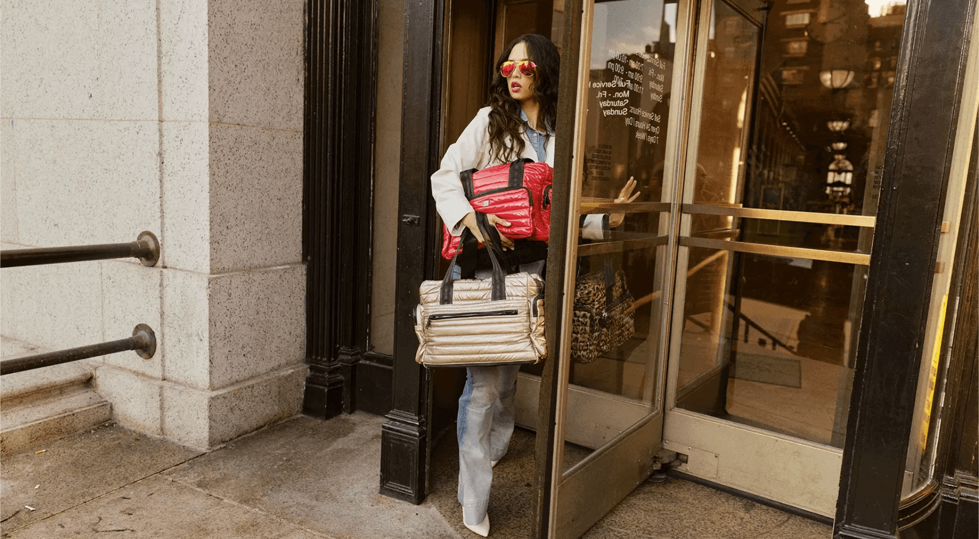 A person holding two bags exiting a building