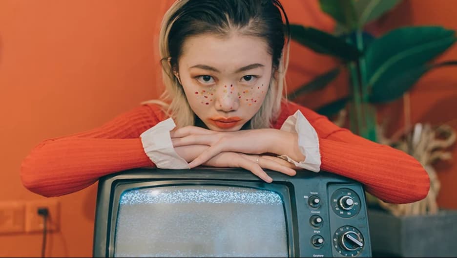 A person with their hands above a TV